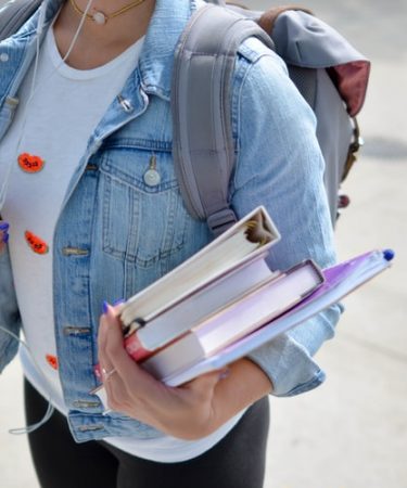 étudiante qui porte des livre avec son sac à dos
