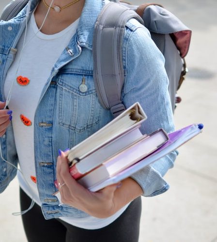 étudiante qui porte des livre avec son sac à dos